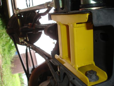 1995 Ford Taurus - Close-up view of a yellow aftermarket suspension component attached to a vehicle's chassis.