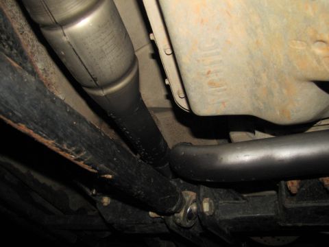 1995 Ford Bronco - Close-up view of the underside of a vehicle, showing mechanical components and some surface rust.