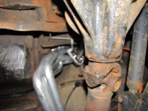 1995 Ford Bronco - Underside view of a vehicle's exhaust and drivetrain components, showing rust and wear.
