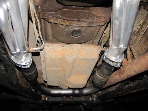 1995 Ford Bronco - Underside view of a vehicle's exhaust system and transmission pan, showing new headers and catalytic converter.
