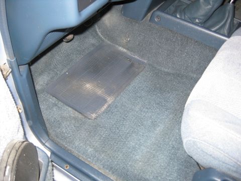 1990 Toyota Pickup/SR5 - Close-up of the interior floor mat and carpet, showing blue dashboard trim and part of a seat.