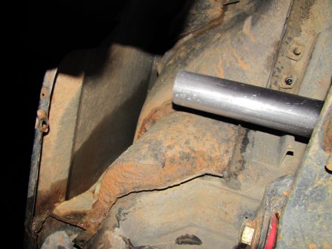 1995 Ford Bronco - Rusted frame and metal pipe visible on the underside of a vehicle.