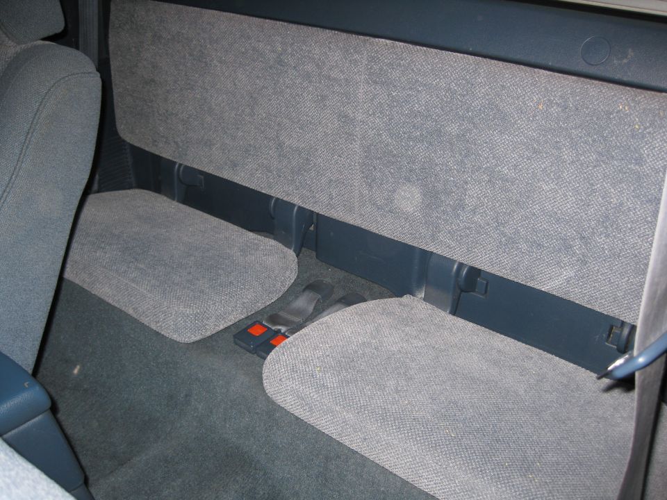 Gray interior rear seats and floor with seatbelts visible
