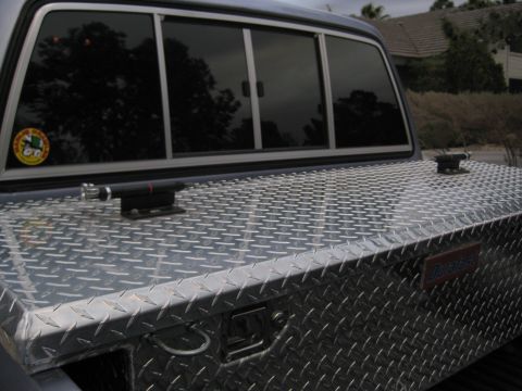 1990 Toyota Pickup/SR5 - Diamond plate truck bed tool box with latch and lock, seen from the side.