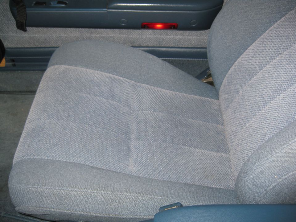 Gray cloth bucket seat in a blue-trimmed truck interior, close-up