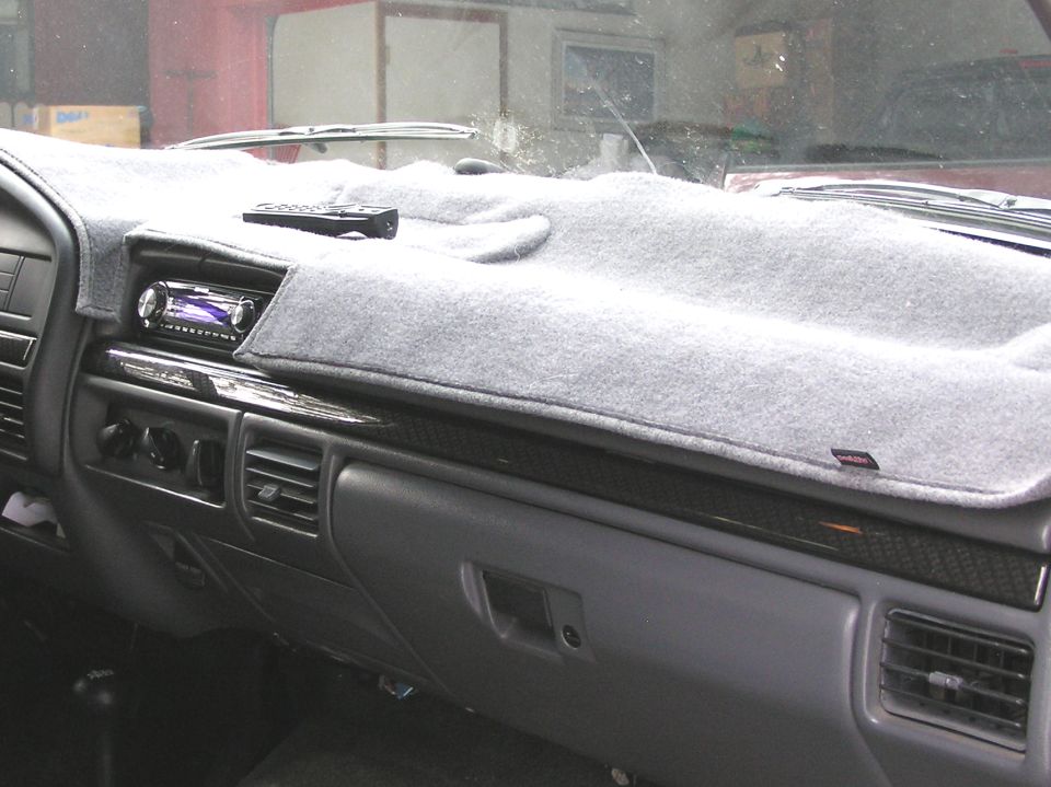Gray dashboard with a gray dash cover, aftermarket stereo, and remote control