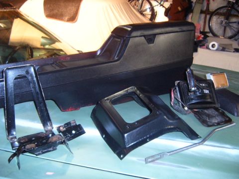 1973 Ford Ranchero - Various interior components, including a center console and shifter assembly, are laid out on a car's dashboard.