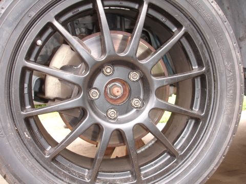 1995 Ford Taurus - Close-up of a black multi-spoke wheel, Yokohama tire, and brake caliper, likely an aftermarket part.