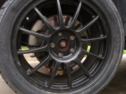 1995 Ford Taurus - Aftermarket wheel and tire assembly, showing the brake caliper and rotor behind the spokes.