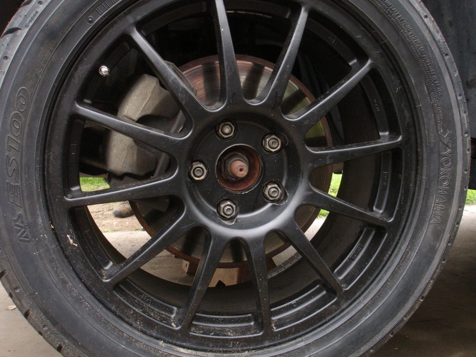 Close-up of a black multi-spoke aftermarket wheel with a Yokohama tire and visible brake caliper