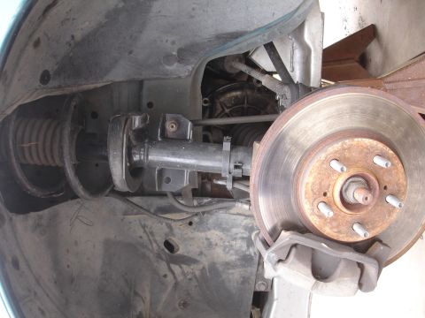 1995 Ford Taurus - Close-up view of a vehicle's suspension system and braking components.