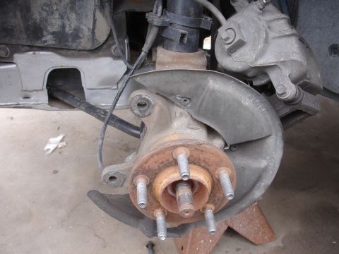 1995 Ford Taurus - Close-up view of a vehicle's front wheel hub and brake caliper assembly.