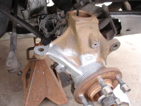 1995 Ford Taurus - A close-up view of a Ford spindle and hub assembly, showing stamped part numbers and rust on the hub.