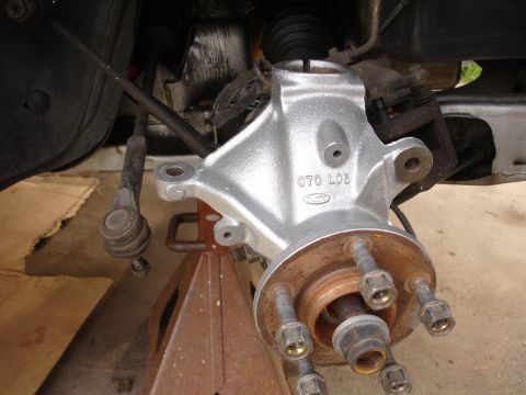1995 Ford Taurus - Suspension knuckle and hub assembly, possibly from a Ford vehicle, shown during a repair or upgrade.