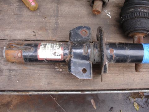 1995 Ford Taurus - A close-up view of a shock absorber part, showing a warning label with text.