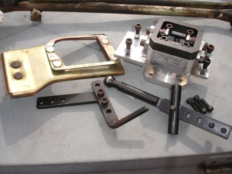 1995 Ford Taurus - A short shifter assembly, including a metal bracket and various hardware components, is laid out on a flat surface.
