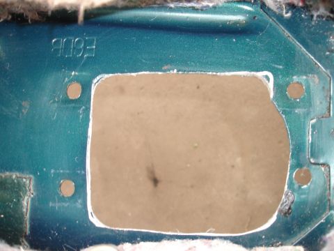 1995 Ford Taurus - A green metal panel shows a cut-out and two bolt holes, with some stamped text visible.