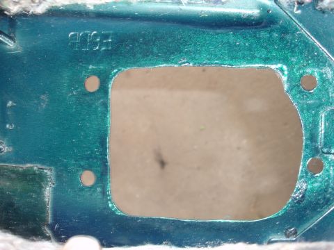 1995 Ford Taurus - A green metal part with a rectangular cutout shows the stamped numbers '1993'.
