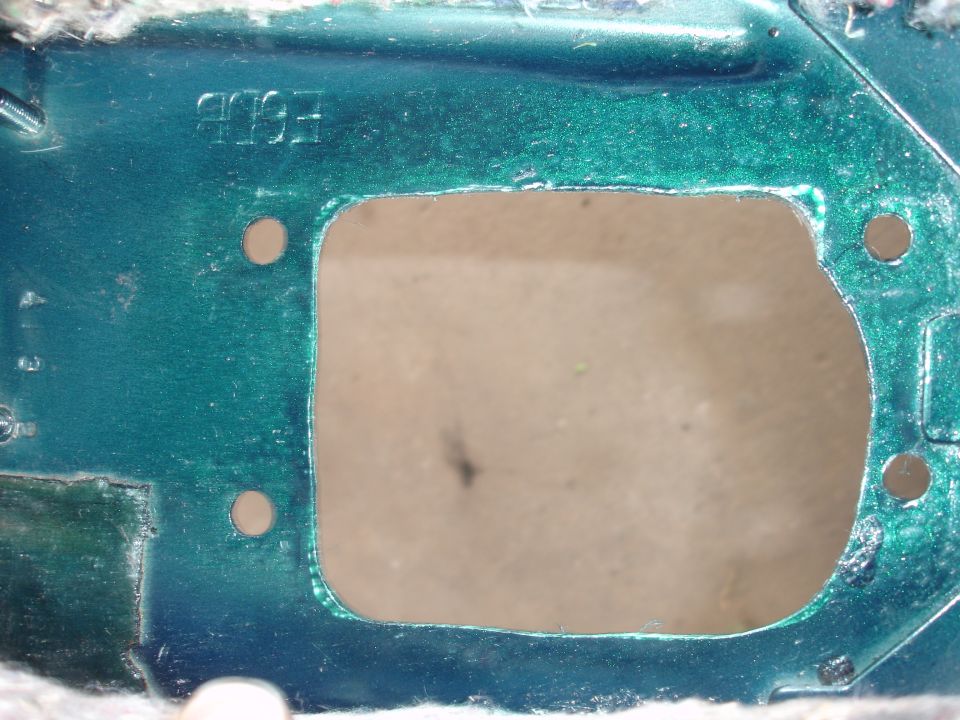 Green metal part with cutout and stamped '1993'