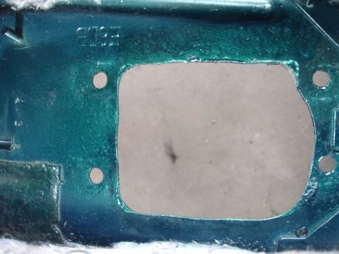 1995 Ford Taurus - Close-up of a green painted metal bracket with 'FORD' stamped into it.