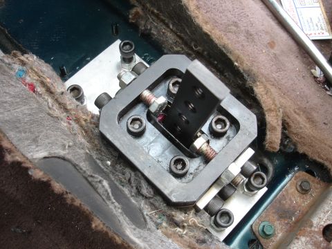 1995 Ford Taurus - Close-up of a modified shifter assembly, showing custom metal parts and fasteners within the car's interior.