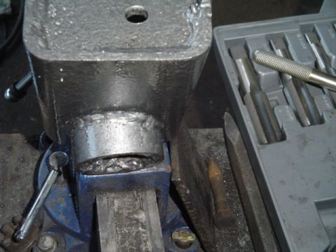 1993 Ford Bronco - A metal component is secured in a vise, with various tools laid out for work.