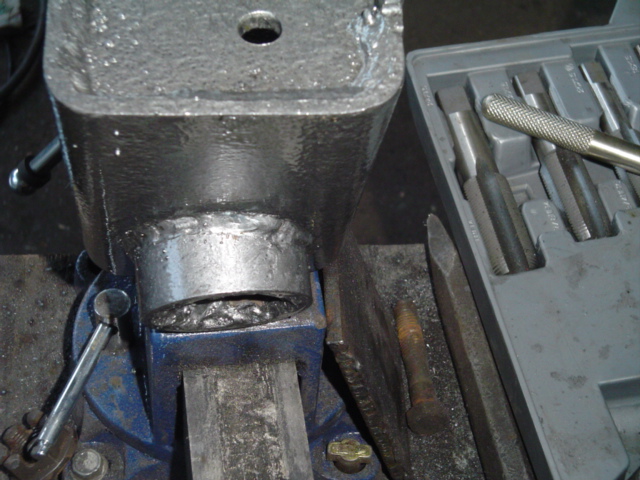 Square steel tube welded to a round bushing sleeve clamped in a blue bench vise