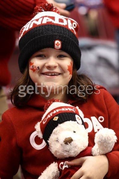1996 Ford Bronco - A young fan proudly displays her Canadian spirit with face paint and a beanie while clutching a teddy bear.