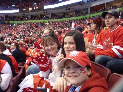 1996 Ford Bronco - Fans dressed in red and white, some with face paint, watch a game in a crowded stadium.