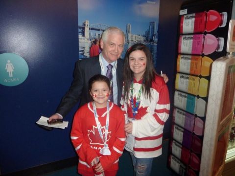 1996 Ford Bronco - A man and two young girls wearing Canadian hockey jerseys pose for a photo at an event, with a Vitaminwater display in the background.