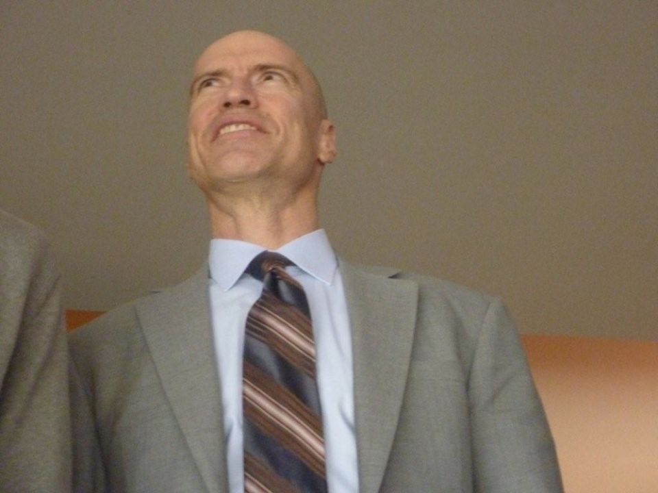 Man in a gray suit and striped tie looks up and to the right