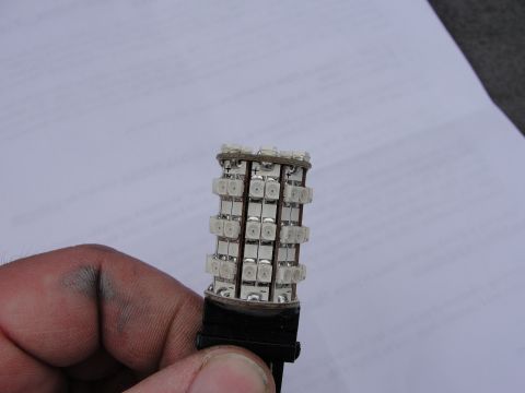 1995 Ford Bronco - Hand holding an LED bulb with multiple diodes, likely a replacement part.