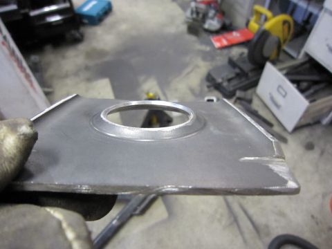 1996 Ford Bronco - A metal component with a central circular opening is held by gloved hands in a workshop setting.