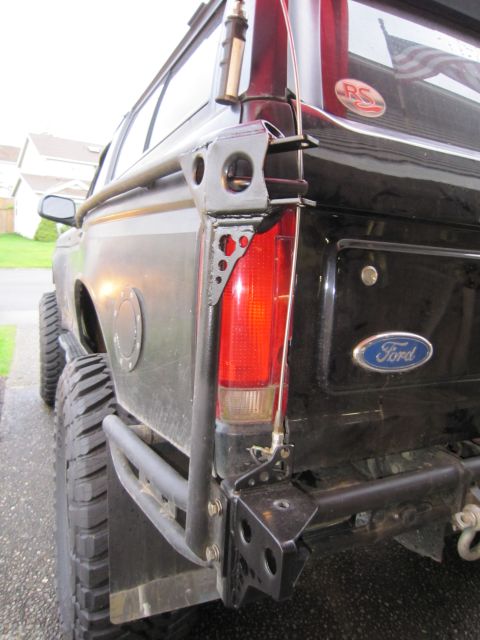1996 Ford Bronco - Custom rear bumper and roll cage on a 1996 Ford Bronco, showing the taillight and Ford emblem.