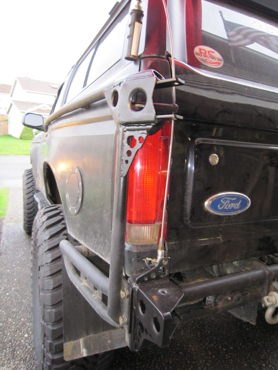 1996 Ford Bronco rear bumper with custom roll cage and taillight assembly. Ford emblem visible on tailgate