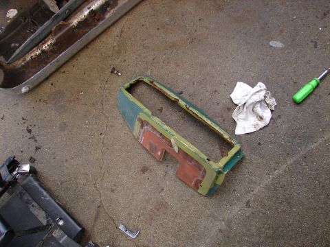 1973 Ford Ranchero - A disassembled car part lies on the ground next to a screwdriver and a crumpled rag.