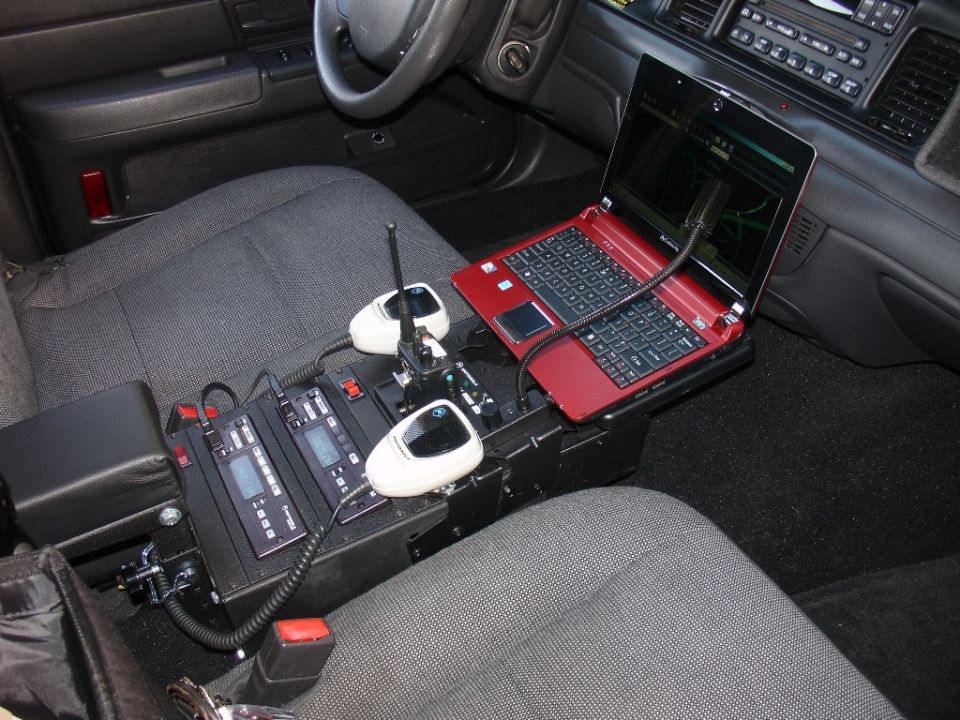 Police car center console with mounted laptop, radios and controls