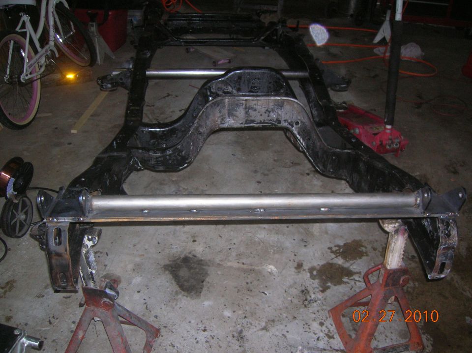 Vehicle frame on jack stands with visible date stamp 02.27.2010