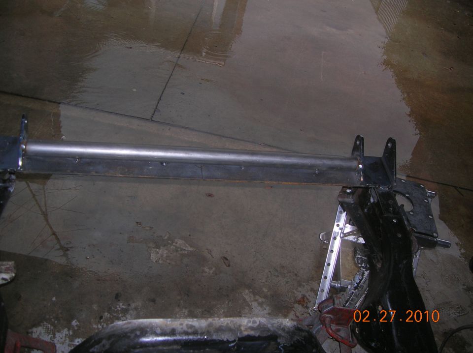Metal tube assembly supported by jack stands on a concrete floor