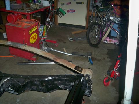 1985 Ford Bronco - A close-up of a vehicle's frame and leaf spring, surrounded by various recreational items.