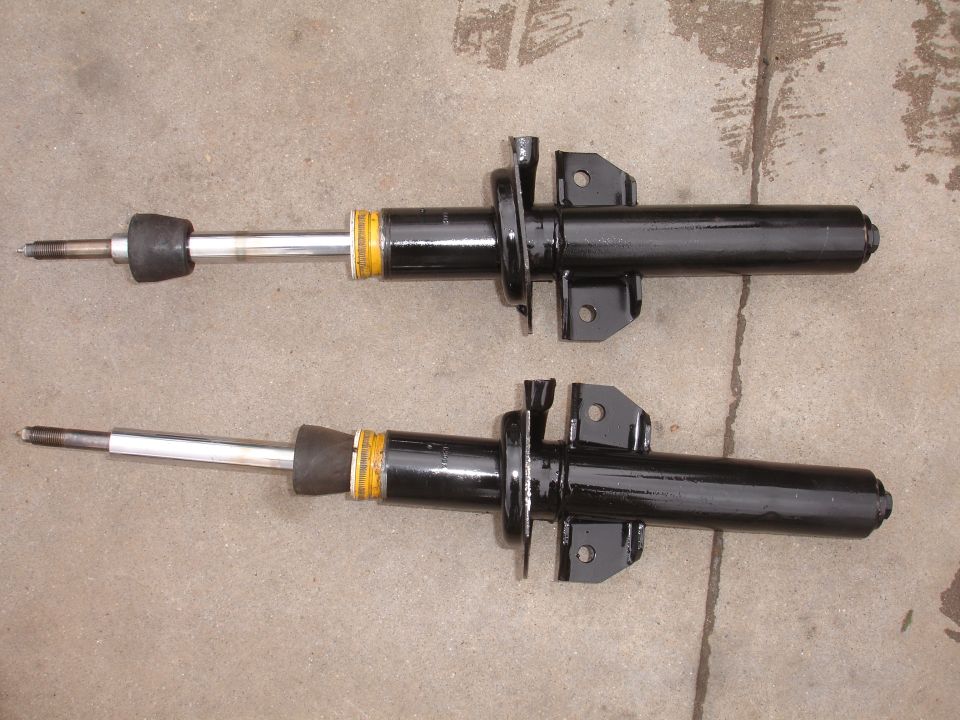 Pair of black front shock absorbers with yellow bands and silver shafts