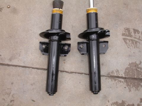 1995 Ford Taurus - Pair of black shock absorbers shown on a concrete surface.