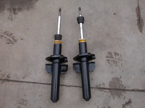 1995 Ford Taurus - A pair of car shock absorbers are displayed on a concrete surface, likely for sale or identification.