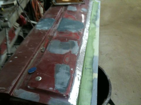1993 Ford Bronco - A car door is being prepped for paint, with visible body filler and primer in various stages of application.