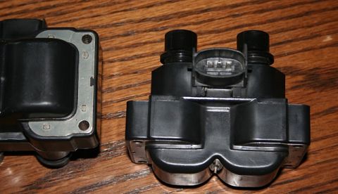 2007 Ford Mustang - Two automotive ignition coils are shown against a wooden background.