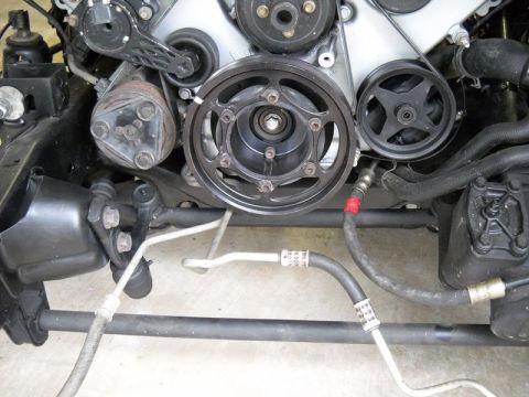 2007 Ford Mustang - Close-up view of an engine's belt and pulley system, including the AC compressor.