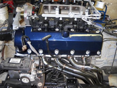 2007 Ford Mustang - Close-up view of a car engine, showing the intake manifold, exhaust headers, and engine block.