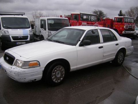 1991 Ford Crown Victoria - This white sedan appears to be a later model Ford Crown Victoria, not a 1991 model as suggested.