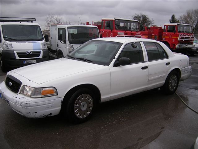 White sedan, side view. Later model Crown Victoria