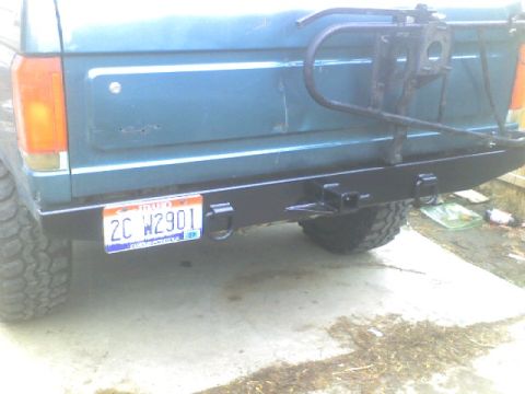 1989 Ford Bronco - Rear view of a teal Ford Bronco, showing its aftermarket bumper and spare tire carrier.